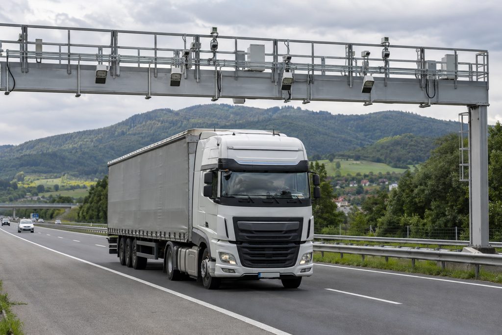 Vrachtwagen rijdt op een Slowaakse snelweg onder een tolportaal met camera's door
