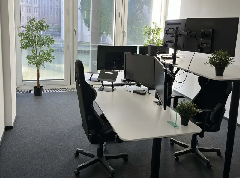 Schreibtisch mit mehreren Monitoren im DMC-Büro